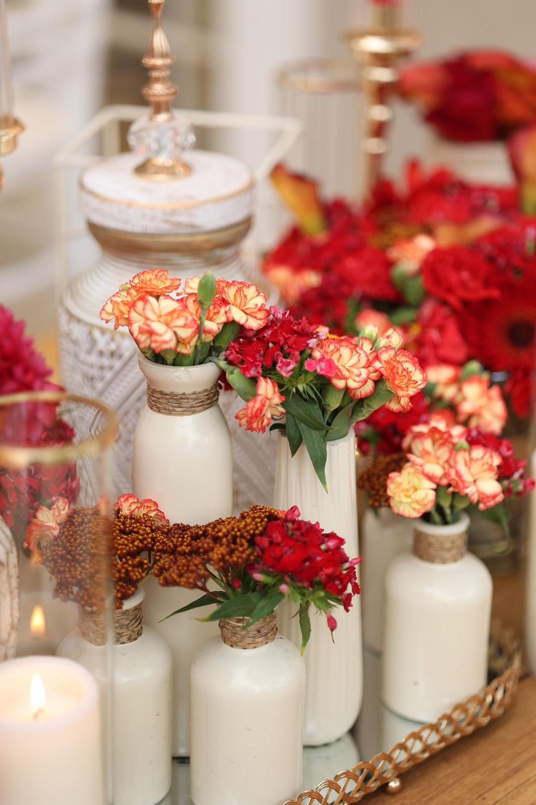 Coral and red flower arrangements with candles