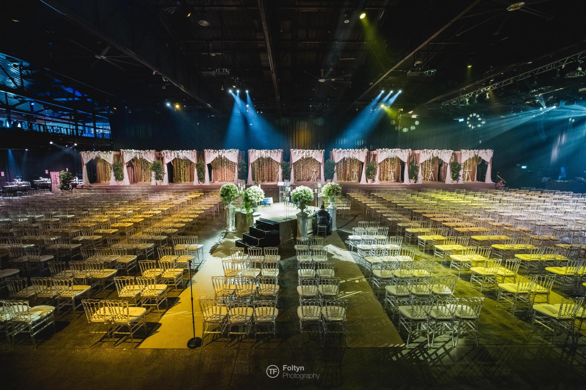 A hall prepared with ten wedding canopies side by side